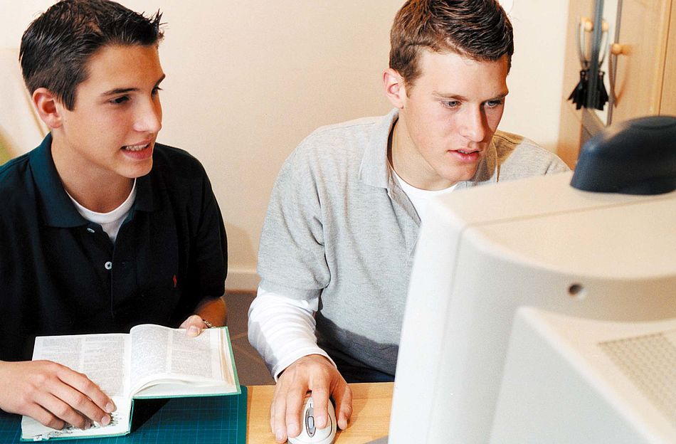 Zwei Jungedliche mit einem Wörterbuch vor dem Computer. - Bildnachweis: © wdv / Katrin Denkewitz Zwei Jungedliche mit einem Wörterbuch vor dem Computer.