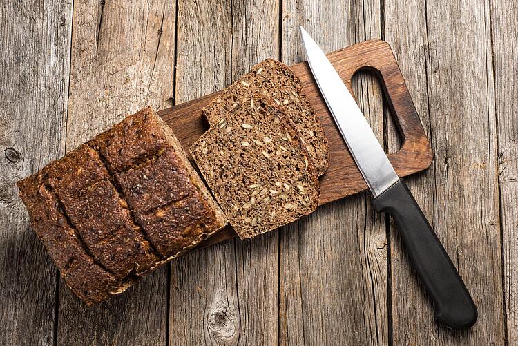 Aufgeschnittenes Vollkornbrot auf einem Holzbrett