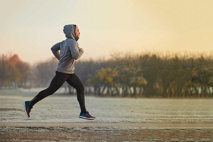 Mann joggt im Herbst bei frostigen Temperaturen