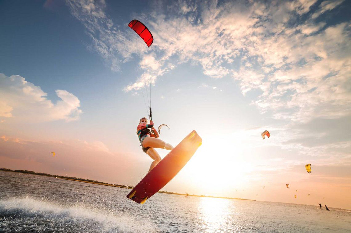 Junge Frau beim Kitesurfen auf einem See