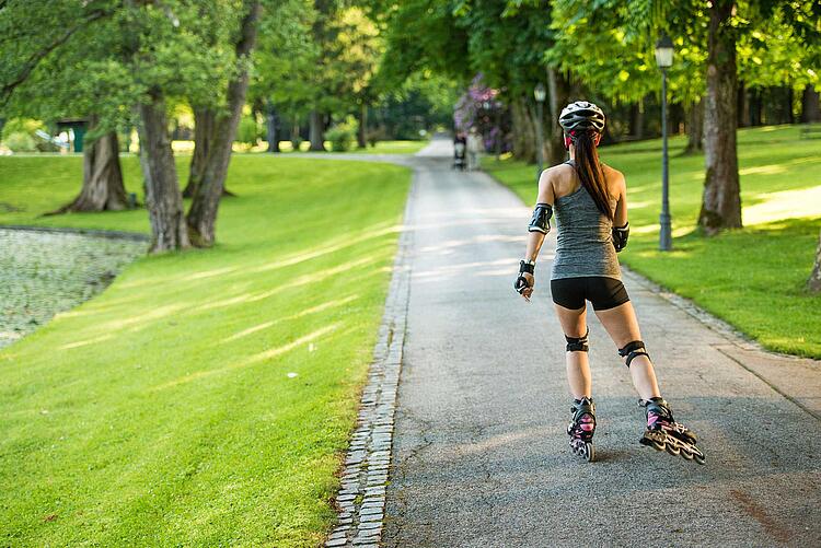 Frau fährt auf Inlineskates im Park.