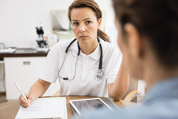 Ärztin im Gespräch mit einem Patienten.