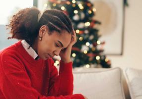 Frau traurig vor einem Weihnachtsbaum Frau traurig vor einem Weihnachtsbaum