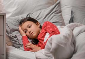 Schlafstörungen bei Kindern: Mädchen liegt schlaflos im Bett