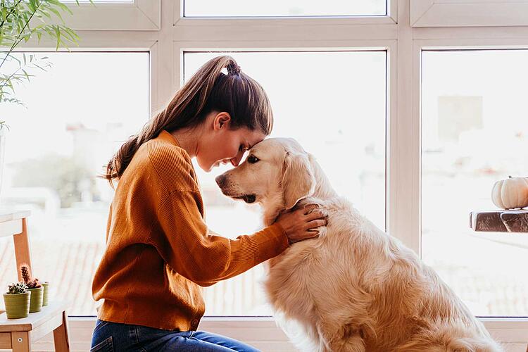 Frau umarmt ihren Hund