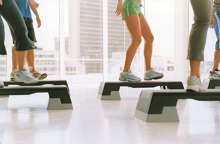 Bildnachweis: © wdv / Jan Lauer Gruppe im Fitnessstudio beim Step Aerobic, Ausschnitt Beine.