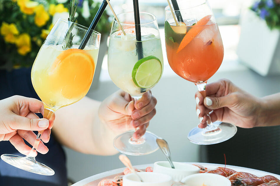 Hände stoßen mit Cocktails an. - Bildnachweis: © istockphoto.com / Mariha-kitchen Hände stoßen mit Cocktails an.