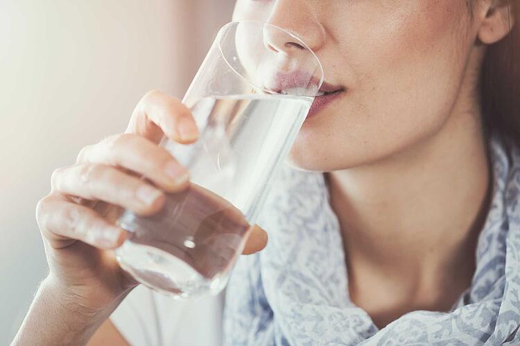 Frau trinkt ein Glas Wasser