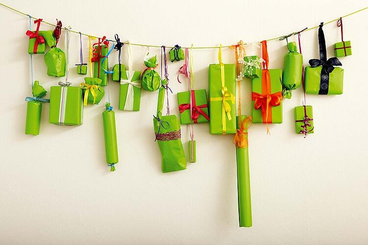 Adventskalender: viele kleine Geschenke hängen an einer Schnur.