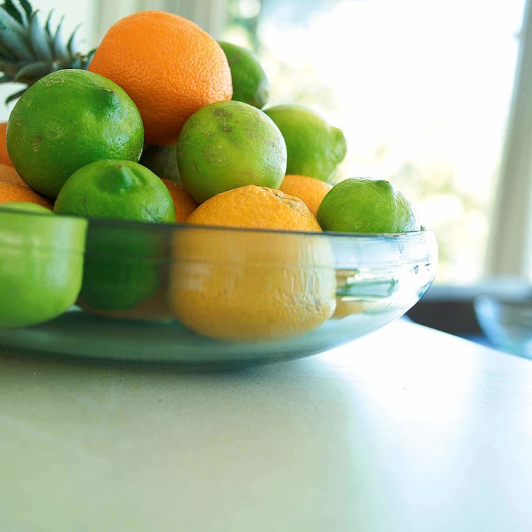Eine Glasschale mit Limetten und Orangen steht auf einem Tisch. - Bildnachweis: © wdv / Olaf Hermann Eine Glasschale mit Limetten und Orangen steht auf einem Tisch.