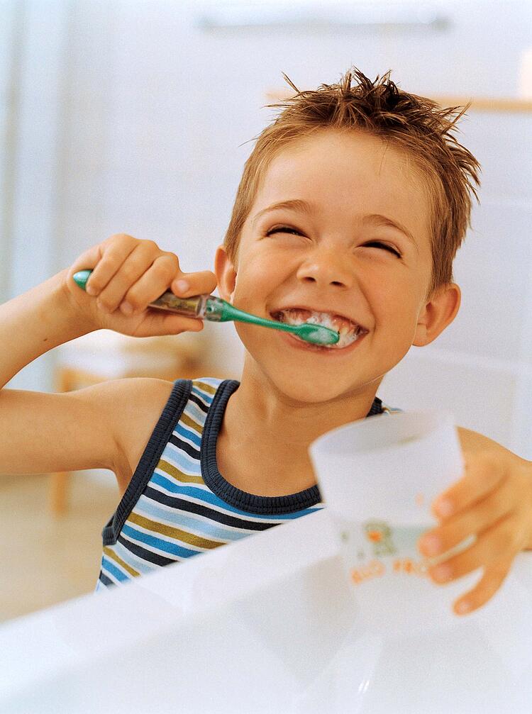 Junge beim Zähne putzen.
